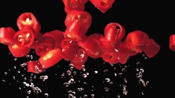 Super slow motion chopped chilli pepper with water droplets. On a black background.Filmed on a high-speed camera at 1000 fps. High quality FullHD footage video