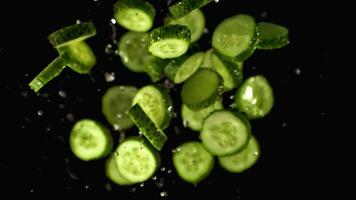 Super slow motion sliced cucumbers with water splashes. On a black background. Filmed on a high-speed camera at 1000 fps. High quality FullHD footage video