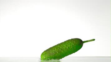 Super slow motion cucumber falls on the water with splashes. On a white background. Filmed on a high-speed camera at 1000 fps. High quality FullHD footage video