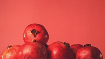 Super slow motion ripe whole pomegranates. On a red background.Filmed on a high-speed camera at 1000 fps. High quality FullHD footage video