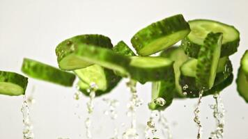 Super slow motion chunks of cucumber soar upwards. On a white background.Filmed on a high-speed camera at 1000 fps. High quality FullHD footage video