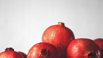 Super slow motion whole pomegranates rise up. On a white background. Filmed on a high-speed camera at 1000 fps. High quality FullHD footage video