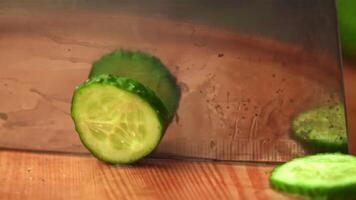 Super slow motion with a large knife cut off a round piece from the cucumber. On a wooden background. Filmed on a high-speed camera at 1000 fps. High quality FullHD footage video