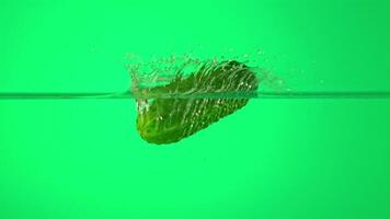 Super slow motion one cucumber falls into water with splashes. On a green background. Filmed on a high-speed camera at 1000 fps. High quality FullHD footage video