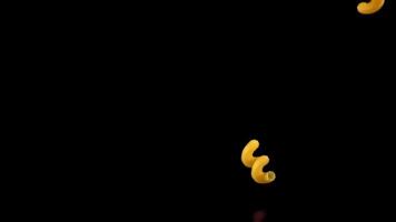 Super slow motion pasta dry cavatappi falls on the table. On a black background. Filmed on a high-speed camera at 1000 fps. High quality FullHD footage video