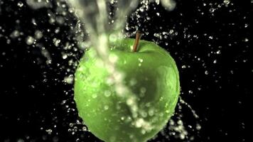 Super slow motion on the rotating apple drops water with splashes. On a black background. Filmed on a high-speed camera at 1000 fps video