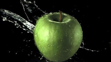 súper lento movimiento verde manzana con salpicaduras de agua. en un negro fondo.filmado en un alta velocidad cámara a 1000 fps video