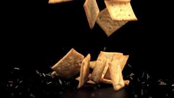 Super slow motion cracker with rosemary falls on the table. On a black background.Filmed on a high-speed camera at 1000 fps. video