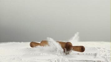 Super slow motion in the flour falls a wooden rolling pin. On a white background.Filmed on a high-speed camera at 1000 fps. video