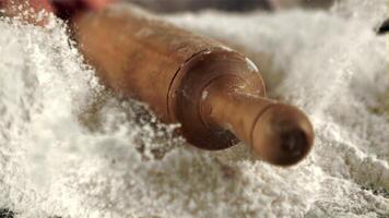 The super slow motion of the wooden rolling pin falls into the flour. Macro background.Filmed on a high-speed camera at 1000 fps. video