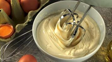 Super schleppend Bewegung Rühren Mayonnaise Rührgerät in das Schüssel. auf ein grau Hintergrund. gefilmt auf ein schnelle Geschwindigkeit Kamera beim 1000 fps. video