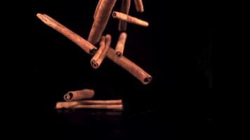 Super slow motion cinnamon sticks fall on the table in a heap. On a black background.Filmed on a high-speed camera at 1000 fps. video