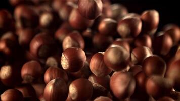 Super slow motion hazelnuts rise up and fall down. On a black background.Filmed on a high-speed camera at 1000 fps. High quality FullHD footage video