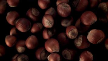 Super slow motion hazelnuts take off and fall down. On a black background. Top view.Filmed on a high-speed camera at 1000 fps. video