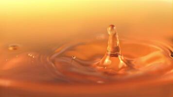 The super slow motion drop falls into the apple juice with splashes. On a yellow background. Filmed on a high-speed camera at 1000 fps. video