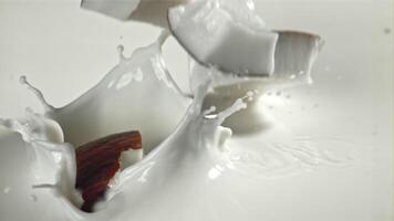 Pieces of coconut fall into the milk with splashes. Filmed on a high-speed camera at 1000 fps. High quality FullHD footage video