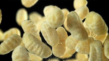 Gnocchi fly up and fall down. Filmed on a high-speed camera at 1000 fps. High quality FullHD footage video