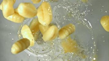 Italienisch Gnocchi fallen in das Wasser mit Spritzer. gefilmt auf ein schnelle Geschwindigkeit Kamera beim 1000 fps. hoch Qualität fullhd Aufnahmen video