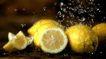 super lento movimento su il limoni gocce acqua con schizzi. su un' di legno sfondo.filmato su un' alta velocità telecamera a 1000 fps. alto qualità FullHD metraggio video