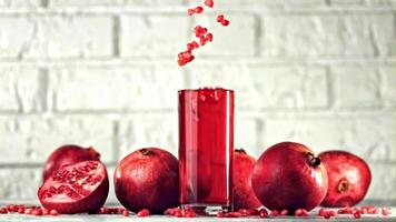 Super slow motion pomegranate grains fall into a glass with pomegranate juice. On a white background.Filmed on a high-speed camera at 1000 fps. High quality FullHD footage video