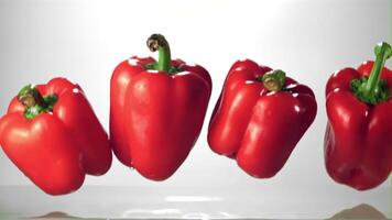 Super slow motion red bell pepper falls into the water with splashes. Filmed on a high-speed camera at 1000 fps.On a white background. video
