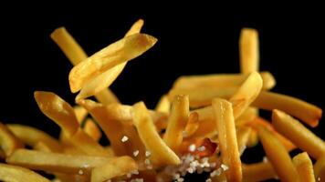 súper lento movimiento francés papas fritas con sal se eleva dentro el aire. filmado en un alta velocidad cámara a 1000 fps.on un negro antecedentes. video