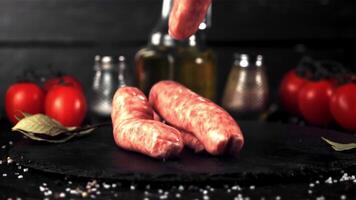 Super slow motion on a stone board fall raw sausage. On a black background. Filmed at 1000 fps. video