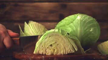 Super slow motion the male hand with a knife cuts the cabbage to pieces. Filmed on a high-speed camera at 1000 fps.On a wooden background. video