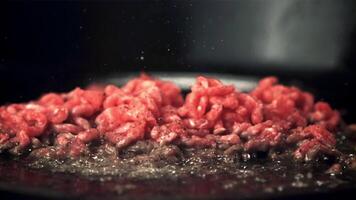 Super slow motion minced meat is fried with a splash of oil. On a black background. Filmed on a high-speed camera at 1000 fps. video