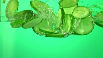 Super slow motion pieces of cucumber under water with air bubbles. On a green background. Filmed on a high-speed camera at 1000 fps. High quality FullHD footage video