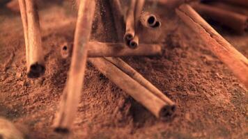 super lento movimento nel un' mucchio su il tavolo caduta cannella bastoni. su un' Marrone sfondo. girato su un' alta velocità telecamera a 1000 fps. video