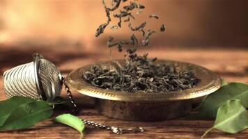 Super slow motion dry tea leaves fall on the plate. On a brown background.Filmed on a high-speed camera at 1000 fps. video