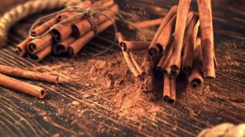 Super slow motion cinnamon sticks fall on a wooden table. On a dark wooden background. Filmed on a high-speed camera at 1000 fps. video