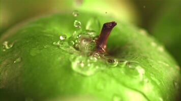 súper lento movimiento en el verde manzana soltar agua con salpicaduras macro fondo.filmado en un alta velocidad cámara a 1000 fps. alto calidad full HD imágenes video