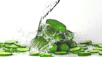 Super slow motion on fresh cucumbers drops water with splashes. On a white background. Filmed on a high-speed camera at 1000 fps. High quality FullHD footage video