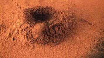 Super slow motion of cocoa flies when the truffle falls. On a brown background.Filmed on a high-speed camera at 1000 fps. video