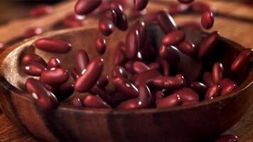 Bean grains fall into a wooden bowl. Filmed on a high-speed camera at 1000 fps. High quality FullHD footage video
