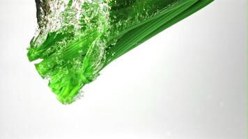 Super slow motion fresh celery falls under the water with air bubbles. On a white background.Filmed on a high-speed camera at 1000 fps. High quality FullHD footage video