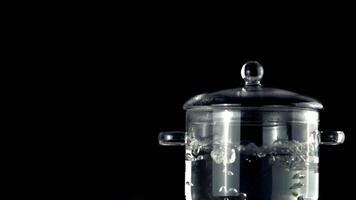 Super slow movement of the pan with boiling water. On a black background. Filmed on a high-speed camera at 1000 fps.High quality FullHD footage video