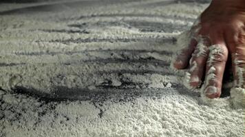 The cook runs his hand over the table with flour. Filmed on a high-speed camera at 1000 fps. High quality FullHD footage video