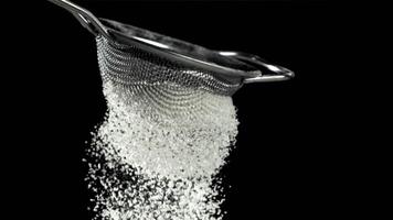 The flour is sifted through a sieve. On a black background. Filmed on a high-speed camera at 1000 fps. High quality FullHD footage video