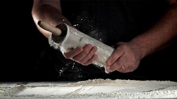 Chef with a rolling pin in his hands and flying flour. Filmed on a high-speed camera at 1000 fps. High quality FullHD footage video