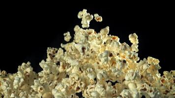 Popcorn flies up and falls down. On a black background. Filmed on a high-speed camera at 1000 fps. High quality FullHD footage video