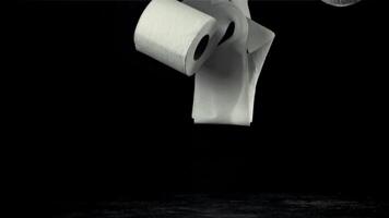 Toilette Papier Stürze auf das Tisch. auf ein schwarz Hintergrund. gefilmt auf ein schnelle Geschwindigkeit Kamera beim 1000 fps. hoch Qualität fullhd Aufnahmen video