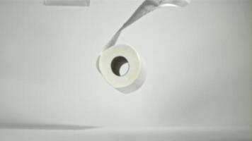 Toilet paper falling on the table on a white background. Filmed on a high-speed camera at 1000 fps. High quality FullHD footage video