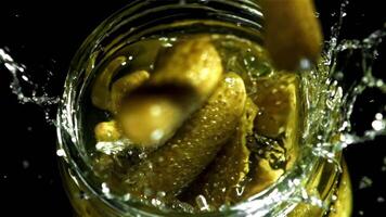 Pickled cucumbers fall into a jar of brine. Filmed on a high-speed camera at 1000 fps. High quality FullHD footage video