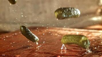 Pickled cucumbers fall on a wooden table. Filmed on a high-speed camera at 1000 fps. High quality FullHD footage video