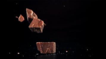 Pieces of chocolate fall on the table. Filmed on a high-speed camera at 1000 fps. High quality FullHD footage video