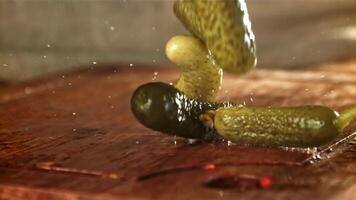 Pickled cucumbers fall on a wooden table. Filmed on a high-speed camera at 1000 fps. High quality FullHD footage video