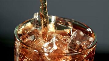 Cola is poured into a glass with ice. Filmed is slow motion 1000 fps. High quality FullHD footage video